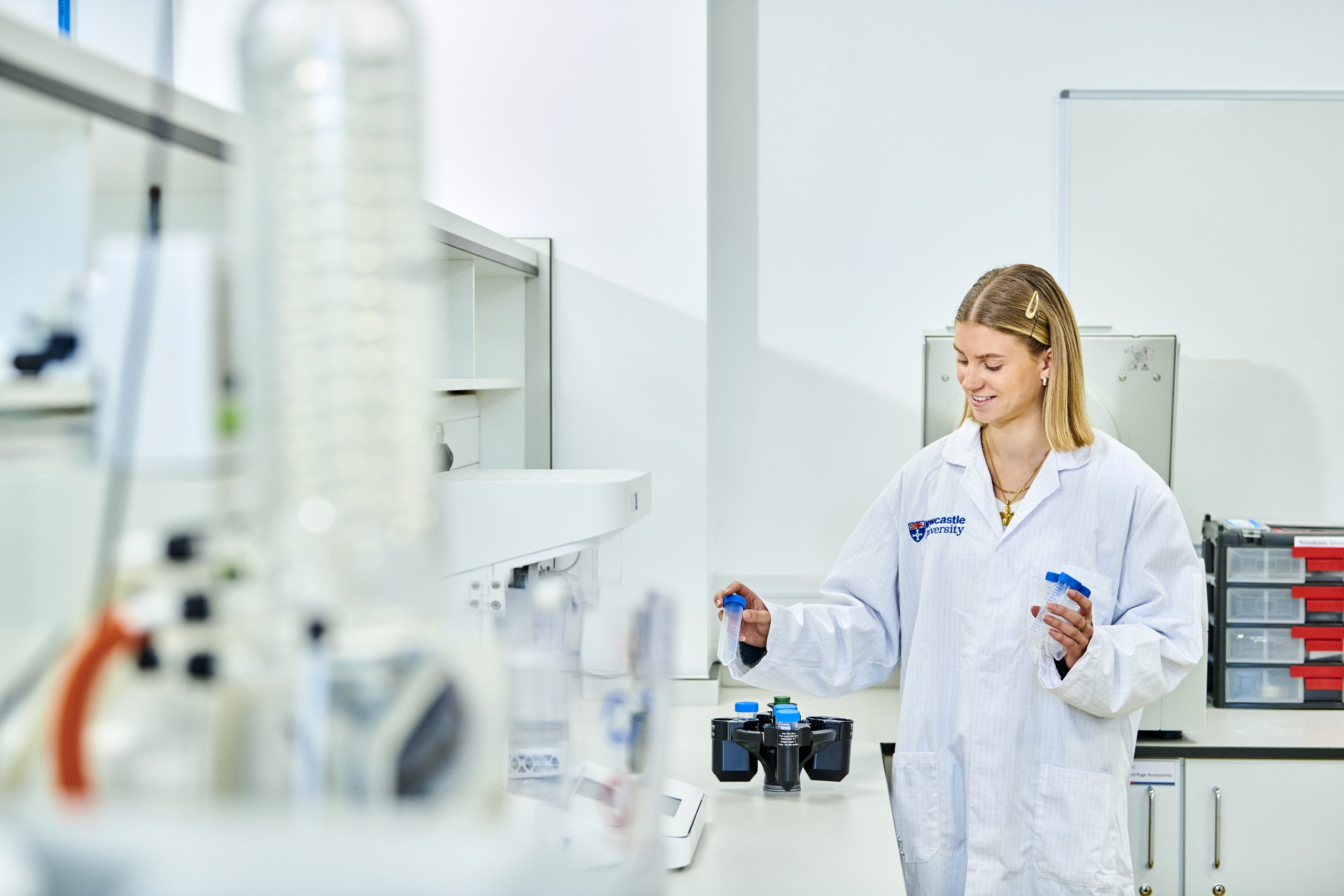 Student wearing a labcoat in a lab